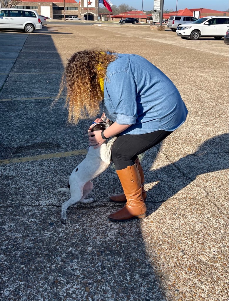 a small dog jumping on a woman